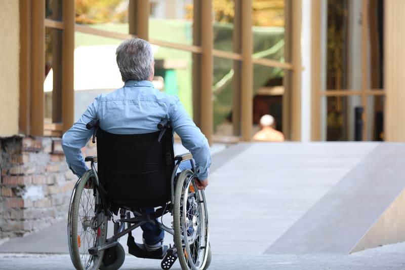 A man using a wheelchair outside an accessible office building