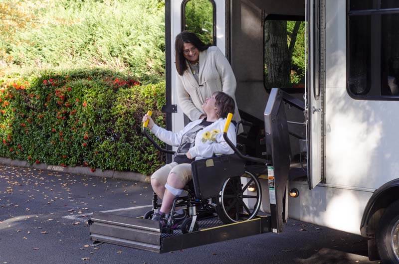A rider boarding an accessible bus using a wheelchair lift