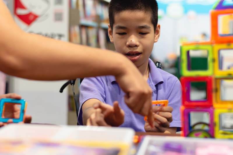 teacher with Student building blocks in class